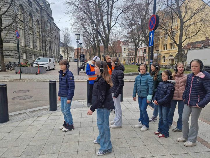 En gruppe mennesker som står på et fortau En gruppe mennesker som står på et fortau