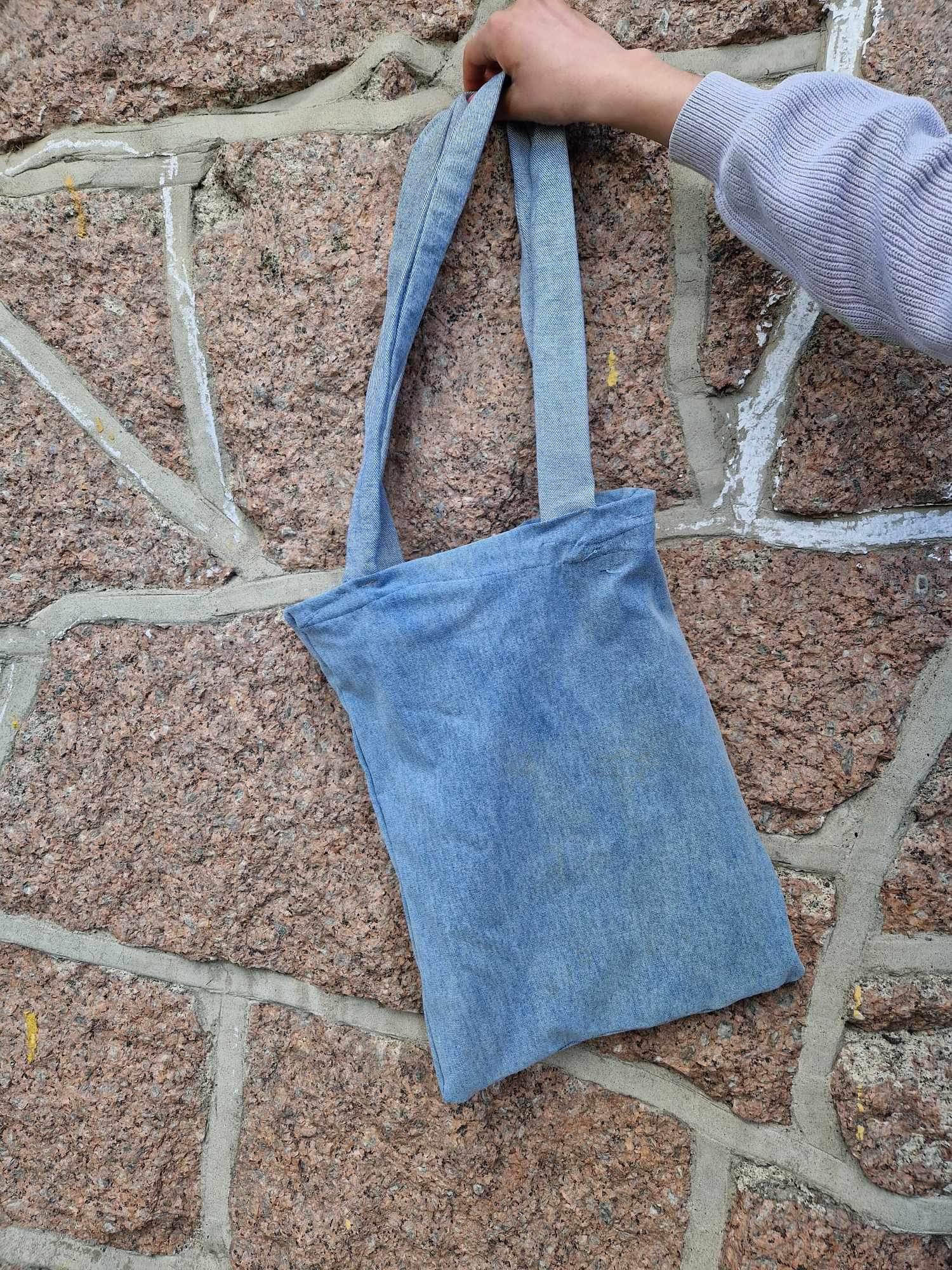 en hånd som holder en blå pose