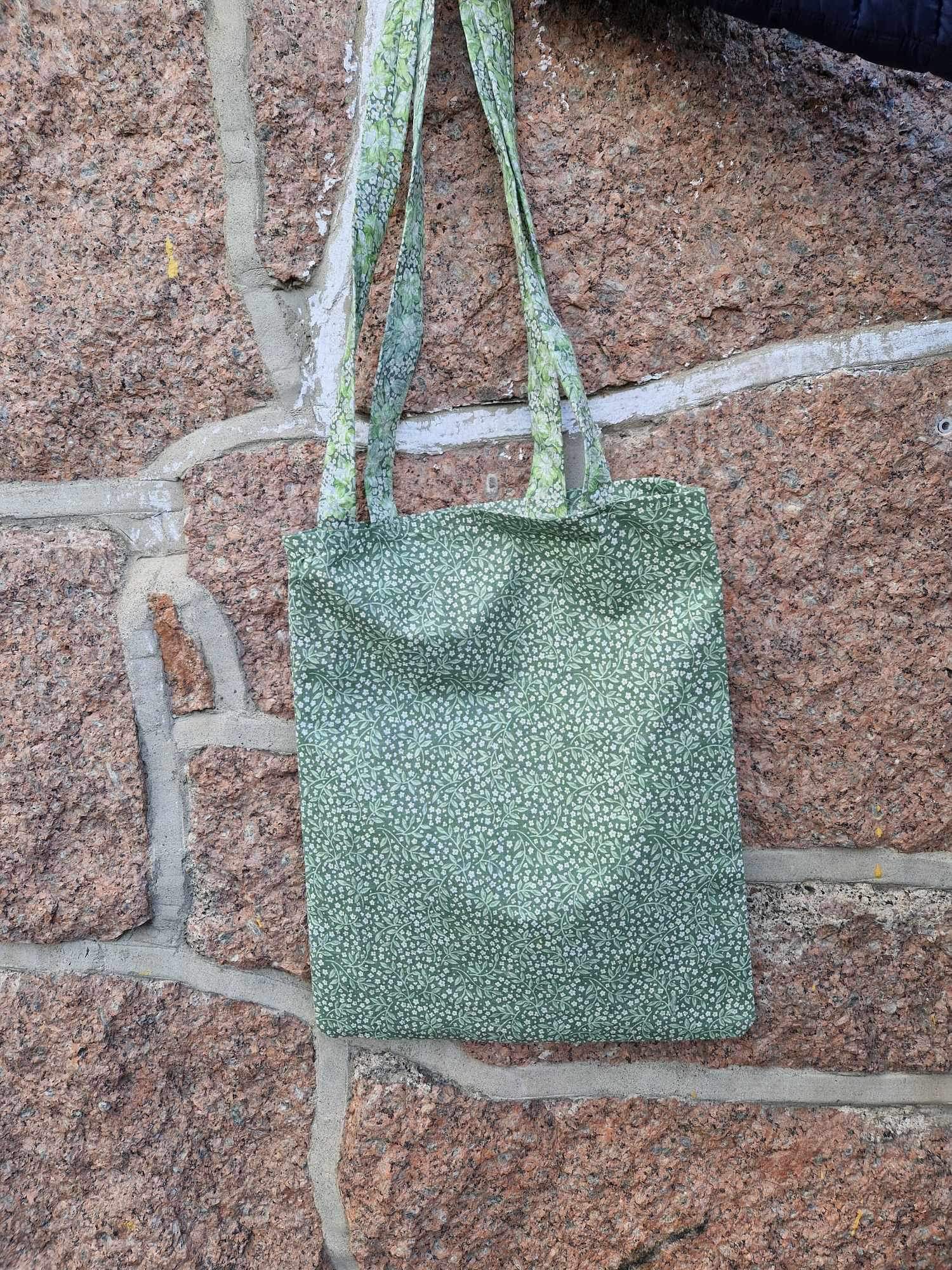 en grønn pose på en mursteinsoverflate