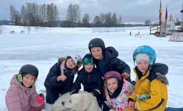 En gruppe barn og en hund i snøen