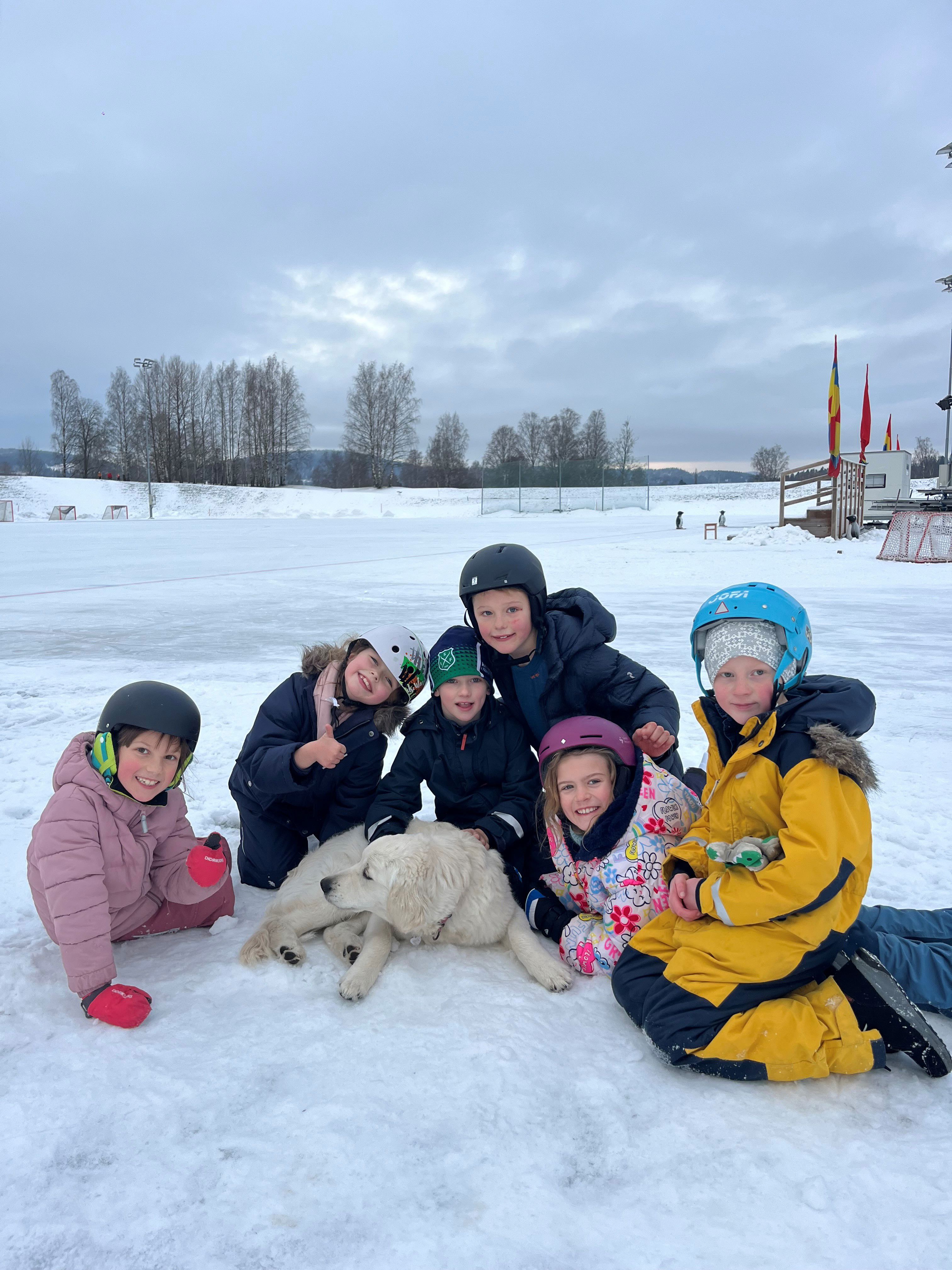 En gruppe barn og en hund i snøen