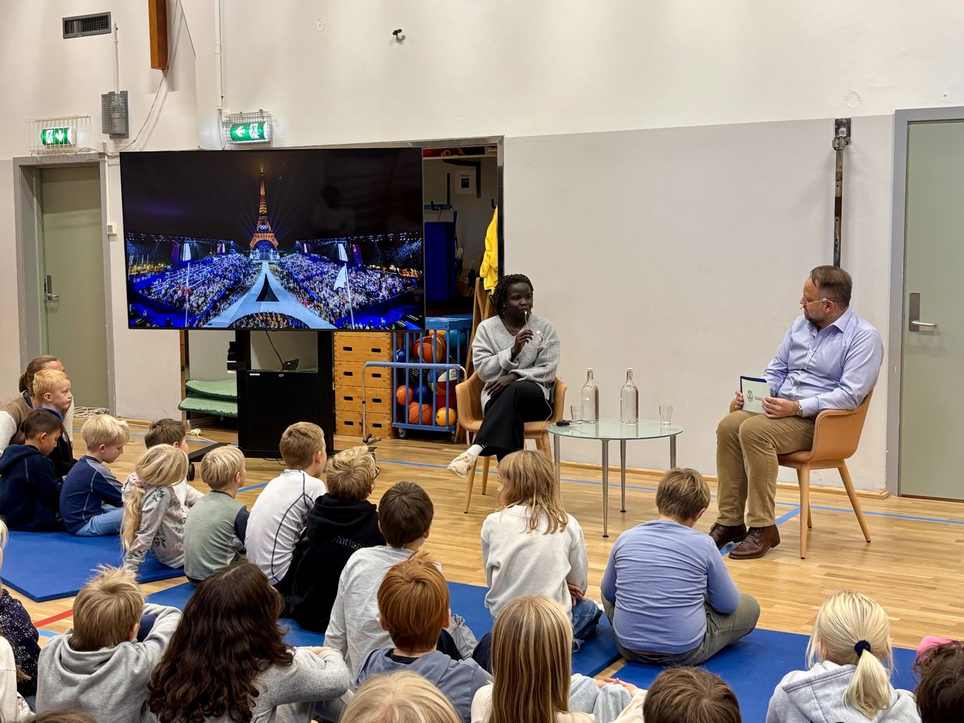 en person og person som sitter foran en gruppe mennesker en person og person som sitter foran en gruppe mennesker