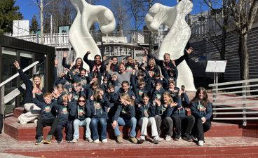 en gruppe mennesker som poserer for et bilde foran en statue