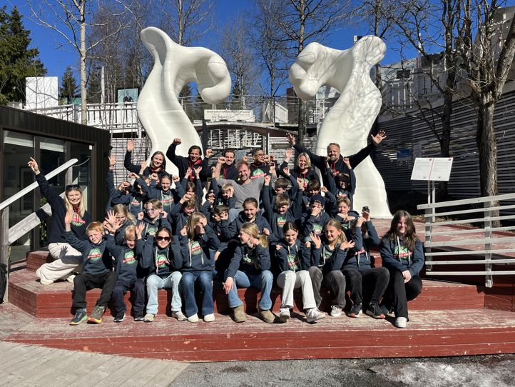 en gruppe mennesker som poserer for et bilde foran en statue en gruppe mennesker som poserer for et bilde foran en statue