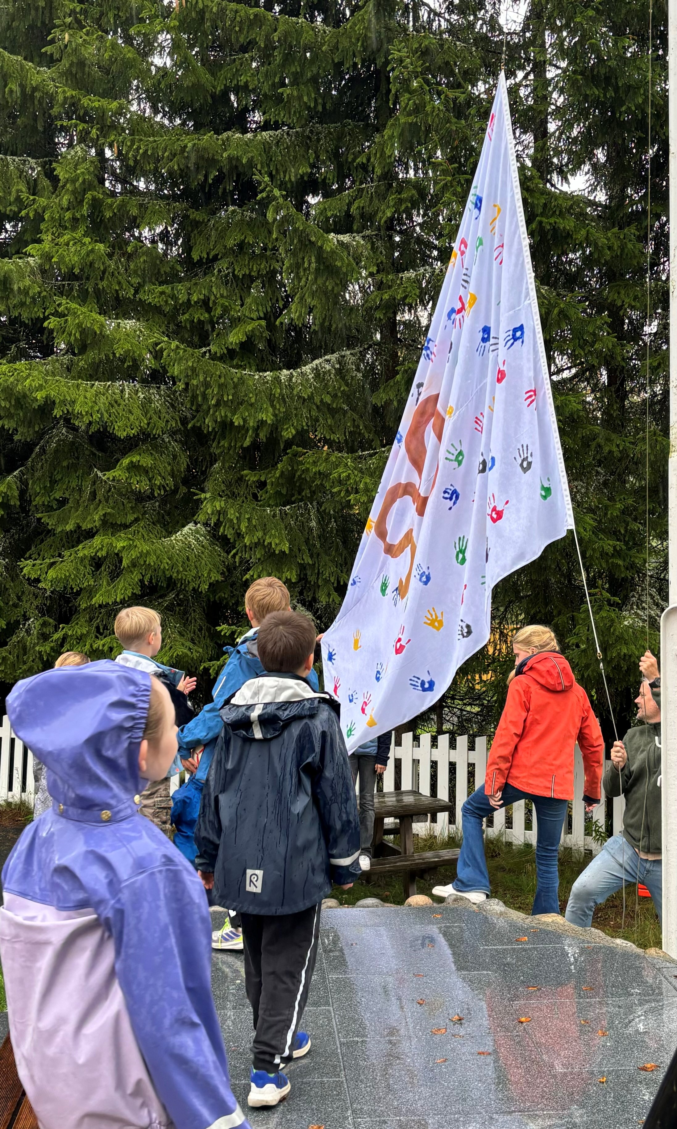 en gruppe mennesker som står rundt et flagg