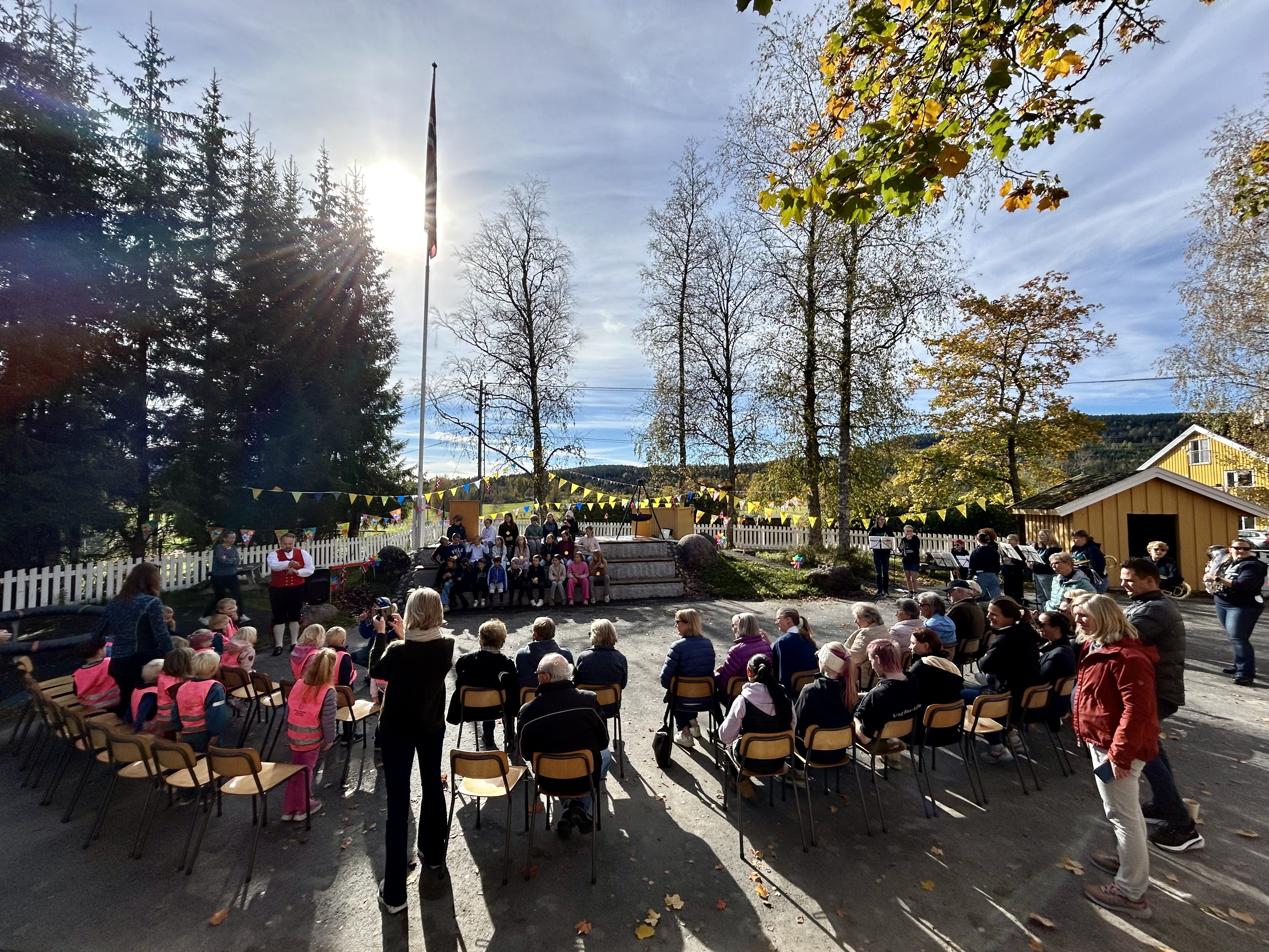 en gruppe mennesker som sitter i stoler utenfor