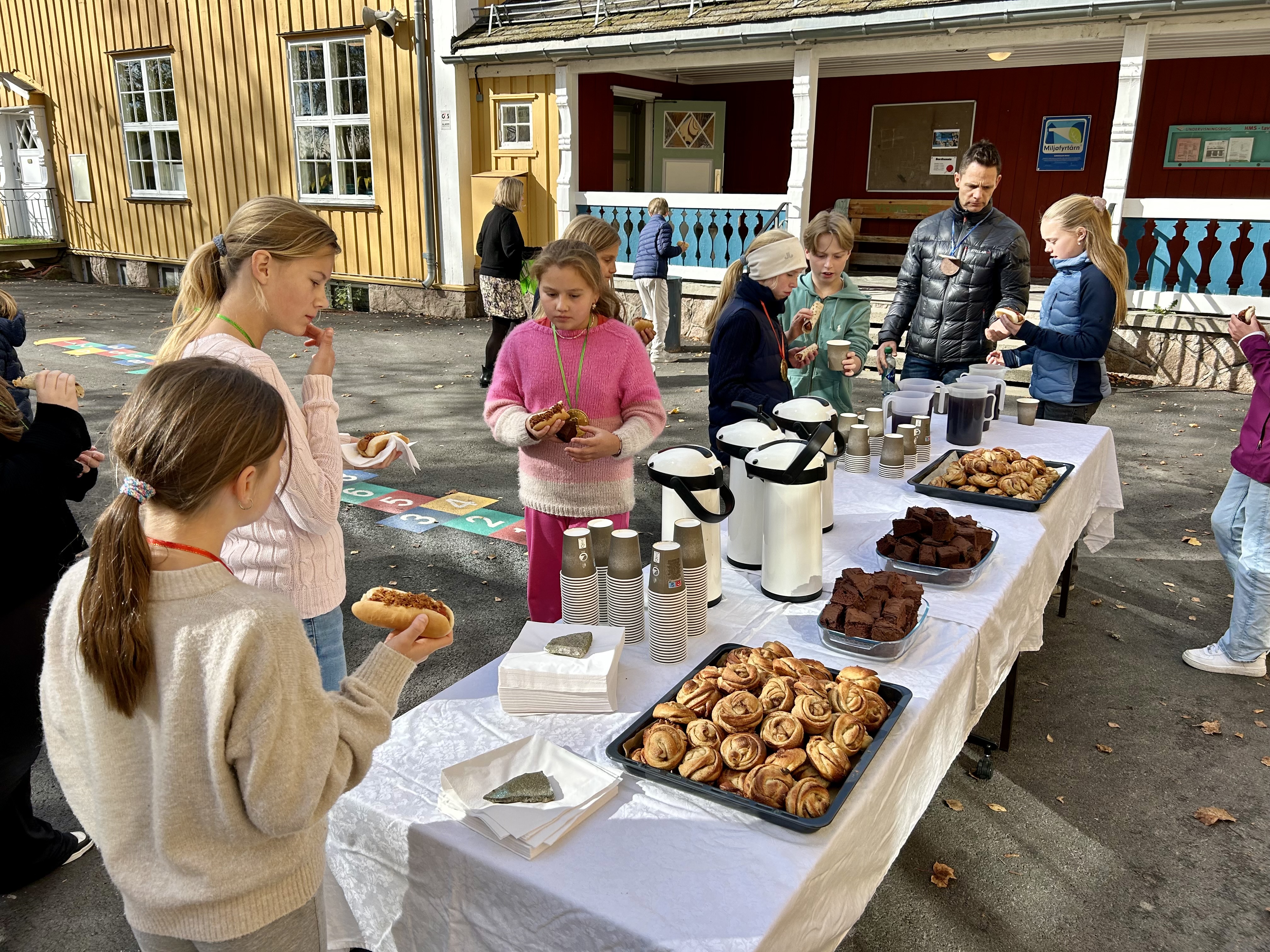 En gruppe mennesker står rundt et bord fullt av smultringer