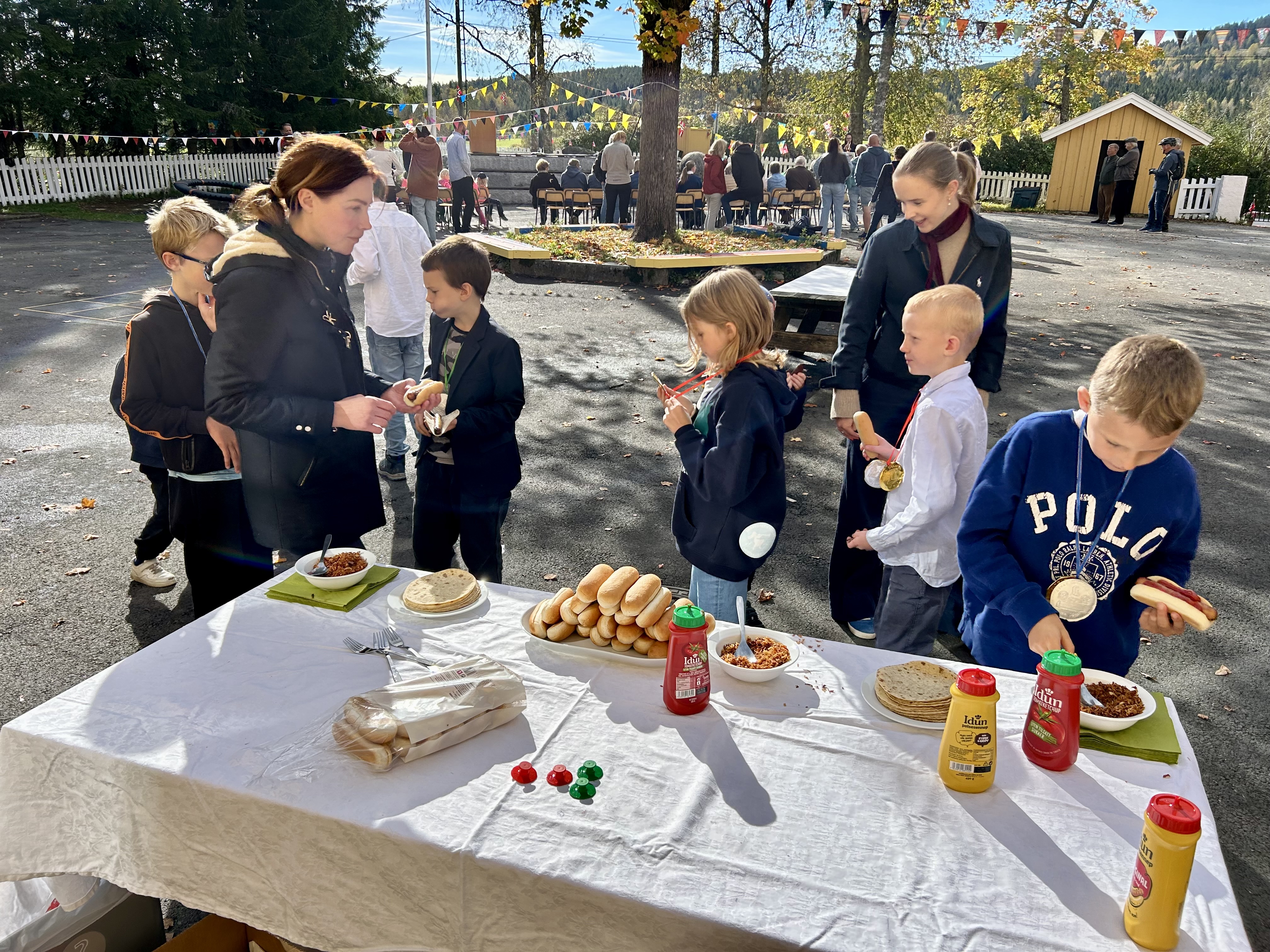 en gruppe mennesker som står rundt et bord med mat på