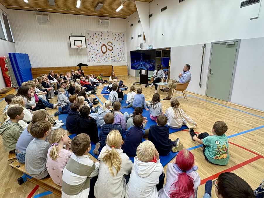 en gruppe mennesker som sitter i et rom og ser på en person på en scene en gruppe mennesker som sitter i et rom og ser på en person på en scene