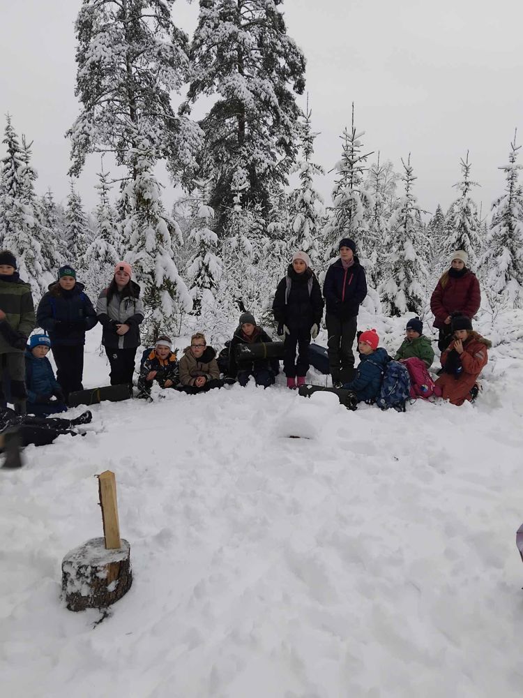 en gruppe mennesker som poserer i snøen