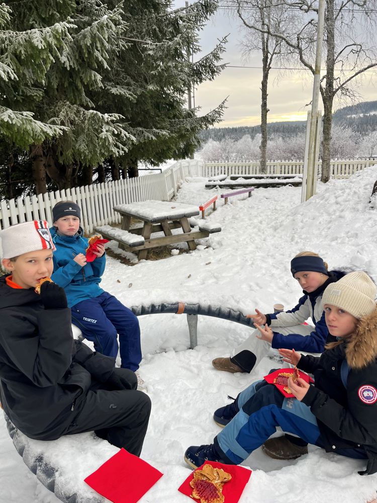 en gruppe mennesker som sitter i snøen