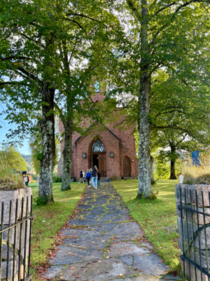 en murbygning med gangvei og trær rundt