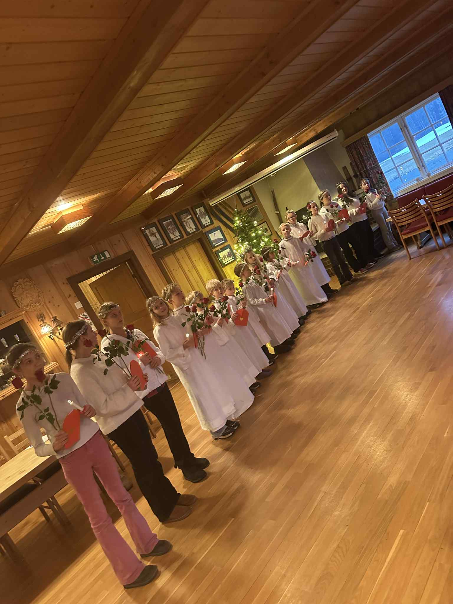 en gruppe mennesker som danser i et rom med bord og stoler