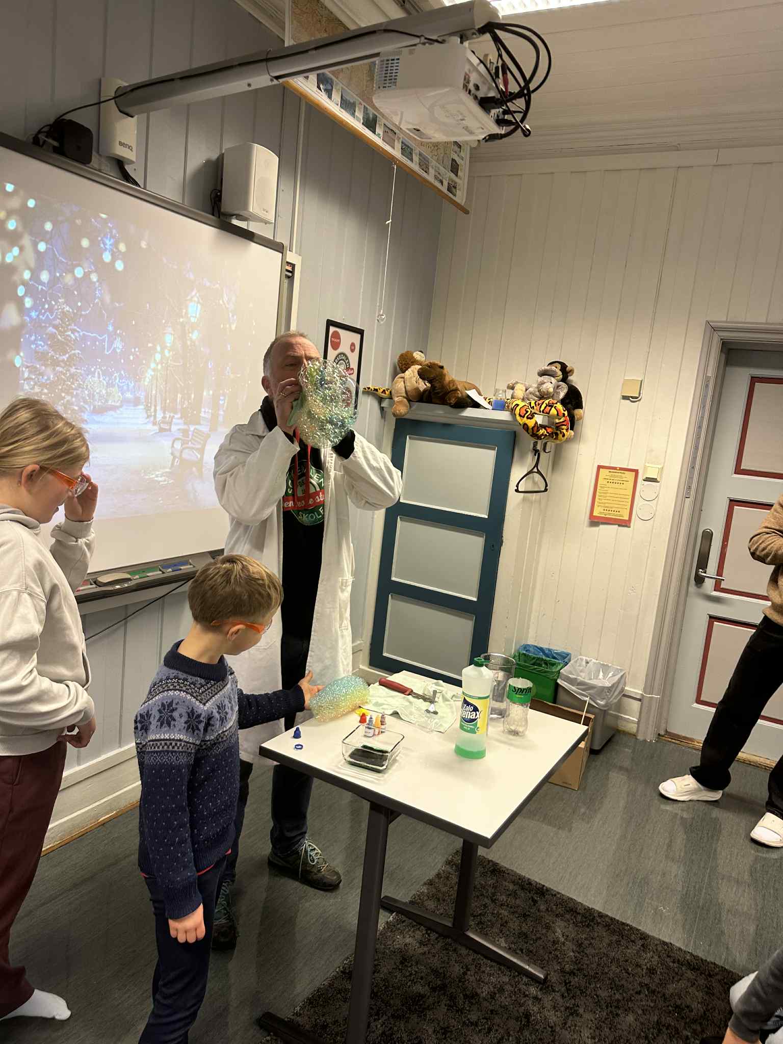 En person og et barn i et rom med et bord og et speil