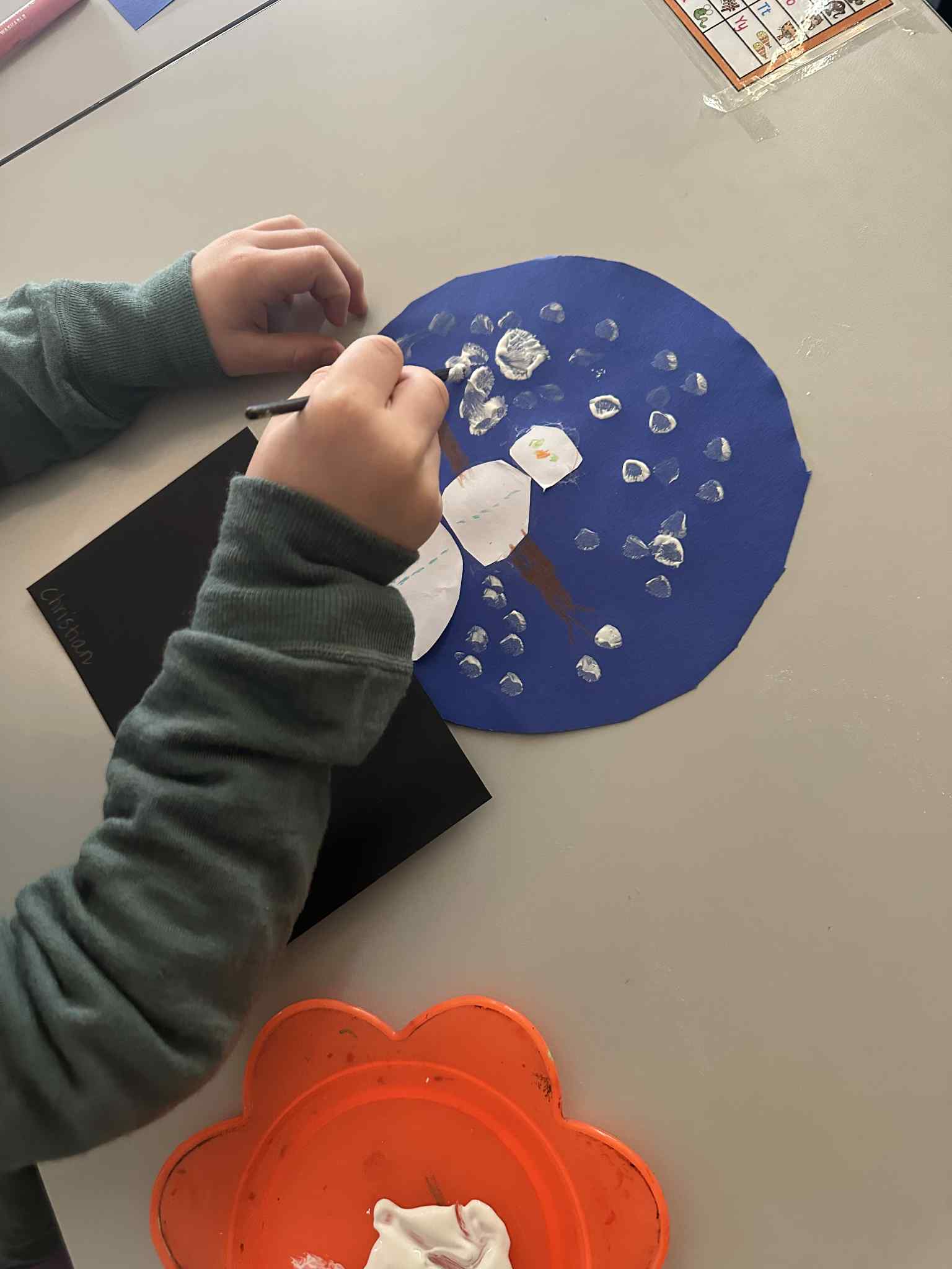 en person som holder en blå og hvit tallerken med en hvit sirkel på